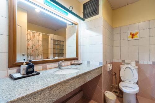 a bathroom with a toilet and a sink and a mirror at Pung-Waan Resort & Spa in Kanchanaburi