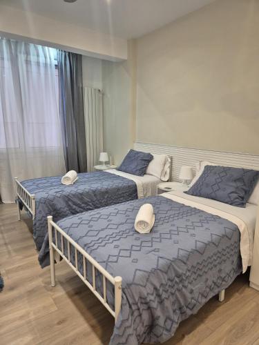 a bedroom with three beds with blue and white sheets at 18 HABITACIÓN EN VIVIENDA CENTRICA BILBAo in Bilbao
