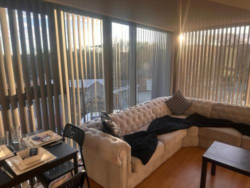 a living room with a couch and a large window at Top floor 2 bedroom retreat in Morley