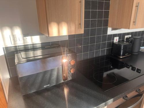 a kitchen with a counter top with a light on it at Top floor 2 bedroom retreat in Morley