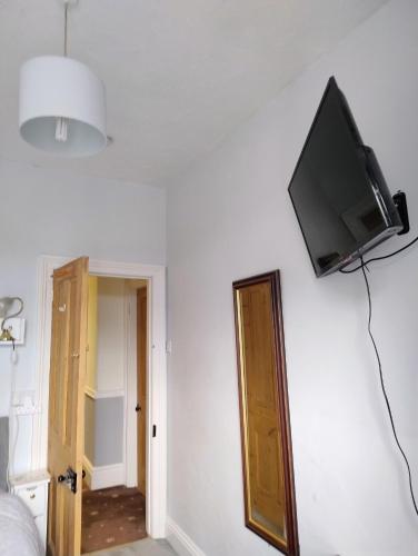 a flat screen tv on the wall of a bedroom at Rooms in historic Bishop Auckland in Bishop Auckland