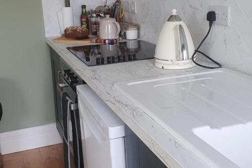 a kitchen counter with a sink and a mixer at Apartment-Sleeps2-Parking-Garden-Patio in Castleisland