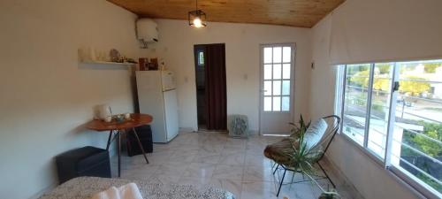 a living room with a table and a refrigerator at Rincón SierraVista in Cosquín
