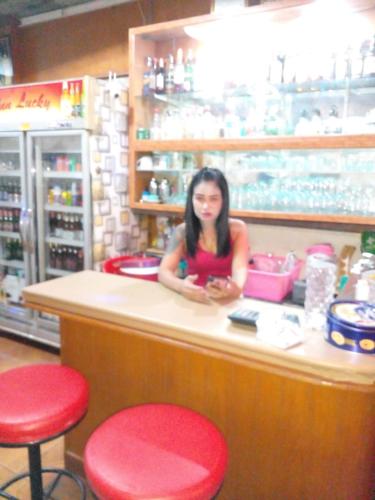 a woman sitting at a counter in a store at Inn Lucky in Jomtien Beach