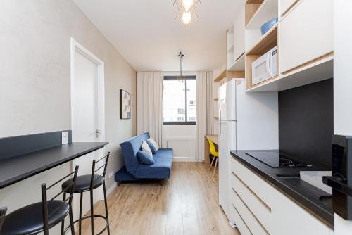 a kitchen with a counter and chairs in a room at Elysia in Curitiba