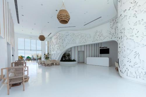 a white lobby with tables and chairs in a building at Meraki Resort Sharm El Sheikh Adults only in Sharm El Sheikh