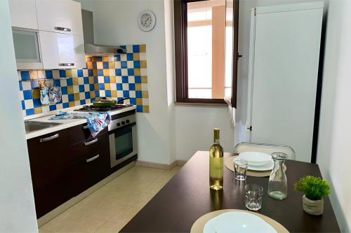 a kitchen with a table with a bottle of wine at Casa Susy in Oristano