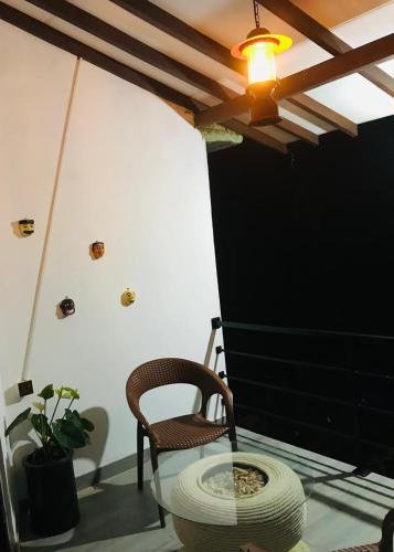 a room with a chair and a glass table at Rainforest Mask villa in Deniyaya