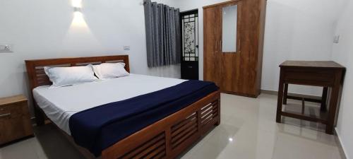 马拉利库兰Sandra Martha Villa的一间卧室配有一张床、床头柜和一张桌子