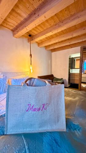 a bag with the namemass k sitting on a bed at Lo Chalet Incantato del Maso K in Folgaria