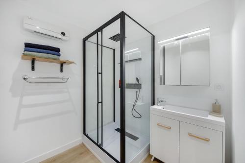 a bathroom with a glass shower and a sink at Appartement T4 Carqueiranne in Carqueiranne