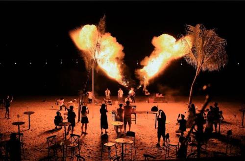 a group of people standing on a beach with fire at VIP Seaview Resort Batu Ferringhi 2104 - 2 Rooms in Batu Ferringhi