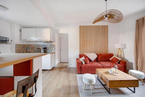 un salon avec un canapé rouge et une table dans l'établissement Appartement T4 Carqueiranne, à Carqueiranne