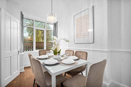 a white dining room with a white table and chairs at Stylish 3-Bedroom House - Garden - Parking - Netflix 18M in Birmingham
