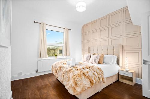 a white bedroom with a large bed and a window at Stylish 3-Bedroom House - Garden - Parking - Netflix 18M in Birmingham