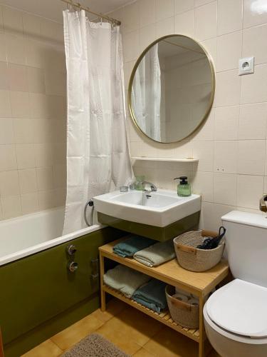 a bathroom with a sink and a tub and a mirror at El rincón de la Rapeda in Villanúa