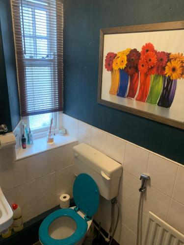 a bathroom with a toilet and a painting on the wall at Low Houses Hadrians Wall in Stagshaw Bank