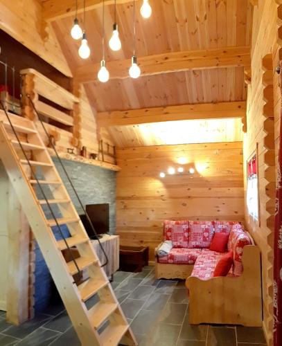 a room with a couch and a staircase in a cabin at Chalet l'UBAC in Bluffy