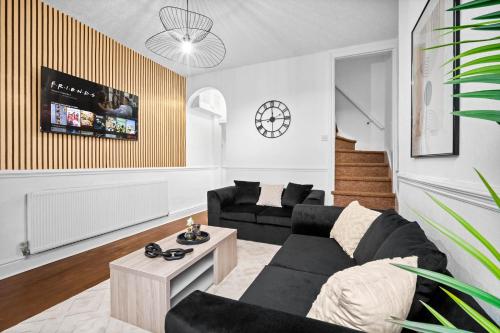 バーミンガムにあるStylish 3-Bedroom Home with Garden & Convenient Parking 18Mの黒いソファとテーブルのあるリビングルーム