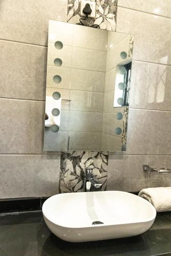 a bathroom with a white sink and a mirror at Hilltop Executive Lodge in Lilongwe