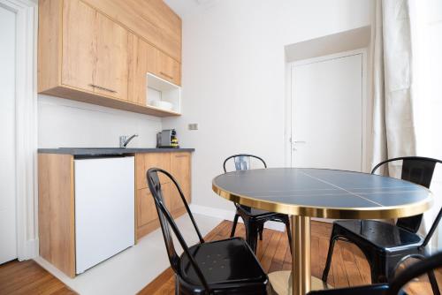 une cuisine avec une table et des chaises dans une pièce dans l'établissement CIA - Louvre museum, à Paris