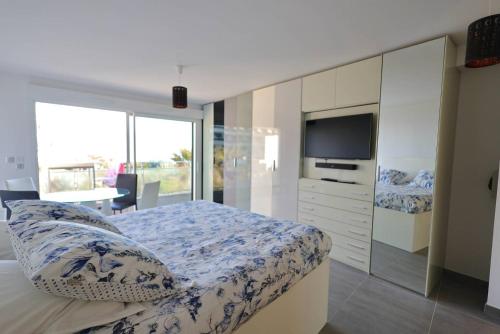 - une chambre avec un lit, une télévision et une commode dans l'établissement NAUTILIA 201 - Luxe - 2 personnes, au Cap d'Agde