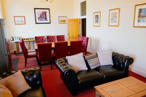 een woonkamer met een bank, een tafel en stoelen bij Station Hotel Larbert in Falkirk