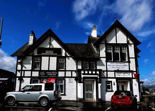 een witte truck geparkeerd voor een gebouw bij Station Hotel Larbert in Falkirk