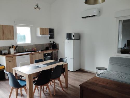 a kitchen with a table and chairs and a dining room at Gîte berclois in Bercloux