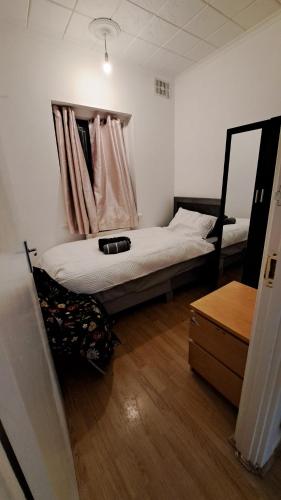 a bedroom with a bed and a mirror in it at Guest house in Dagenham East by Fenia in Dagenham