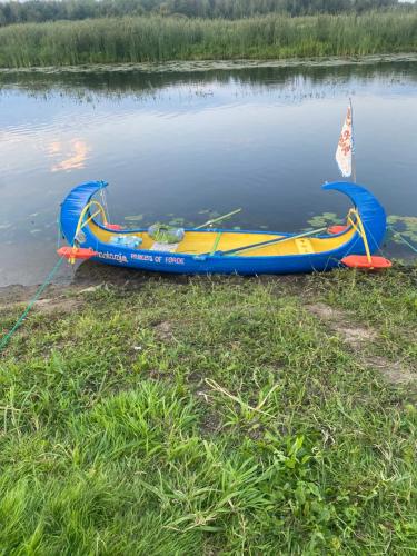 a boat with a sail sitting in the water at Biebrzańska Przystań 3 in Goniadz