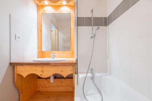 une salle de bain avec un lavabo et un miroir dans l'établissement Le Hameau SPA & PISCINE appartement 3 pieces 6pers by Alpvision Residences, à Orelle