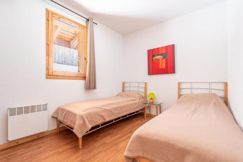 deux lits dans une chambre avec une fenêtre dans l'établissement Le Hameau SPA & PISCINE appartement 3 pieces 6pers by Alpvision Residences, à Orelle