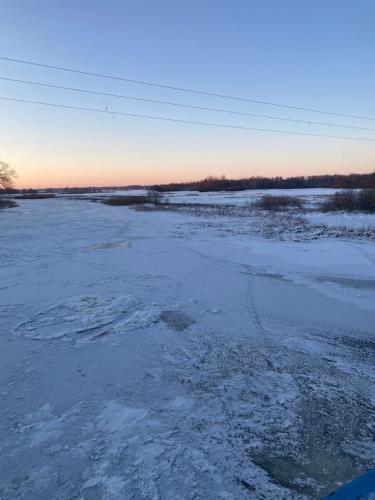 a frozen river with snow on the ground at Biebrzańska Przystań 3 in Goniadz
