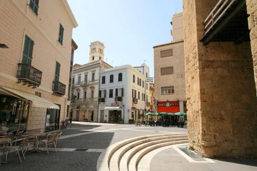 a city street with tables and chairs and buildings at Casa Susy in Oristano