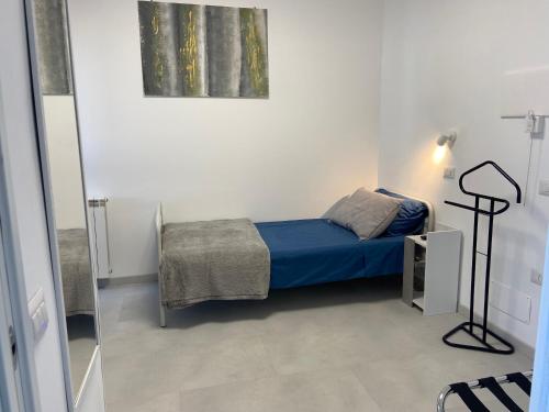 a small bedroom with a blue bed and a mirror at BnB Brotzu in Selargius