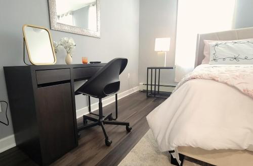 a bedroom with a desk with a bed and a mirror at Jersey Haven NYC Next Door - Single car FREE PARKING in Fairview
