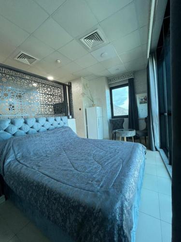 a bedroom with a large bed with a blue blanket at Grand studio en plein centre-ville d'Oran in Oran