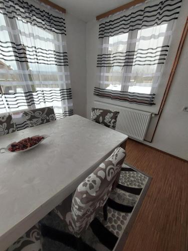 a dining room with a table and chairs and windows at Natura hause in Rakovica