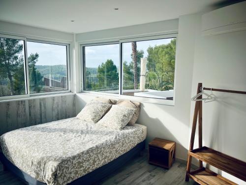 une chambre avec un lit et deux fenêtres dans l'établissement Maison d'hôtes et appartement Villa Palma, à Montferrier-sur-Lez