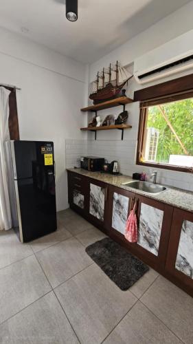 a kitchen with a black refrigerator and a sink at 1 Bedroom Ensuite Beach House in Nasugbu