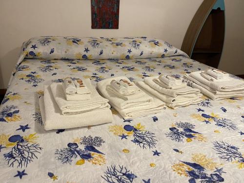 a bed with towels and towels on top of it at Deliziosa casa a Fregene in Fregene