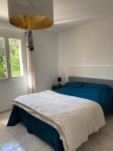 - une chambre avec un lit bleu et blanc et une fenêtre dans l'établissement Villa Giens - Plage à pied -9 couchages, à Hyères