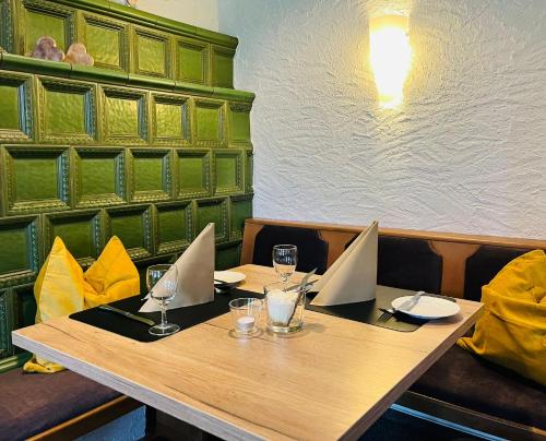 a wooden table in a restaurant with glasses on it at Hotel-Restaurant Kohlenbacher-Hof in Waldkirch