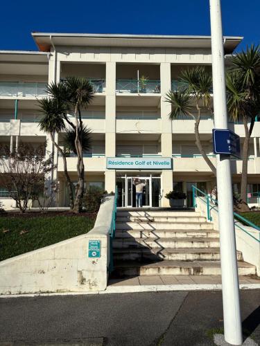 a building with a sign for the entrance to ansics court of money at Appartement Ciboure golf et Nivel in Ciboure