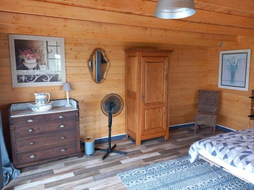 a bedroom with a bed and a wooden wall at Chalet chez le breton des marais in Bouin