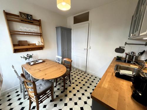 - une cuisine avec une table en bois, des chaises et un évier dans l'établissement Delorme 2pers Tv & Wifi, à Nantes