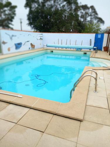 a large swimming pool with a tile floor and aicrobialicrobialicrobial at Chalet chez le breton des marais in Bouin