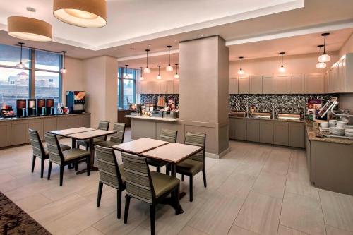 a restaurant with tables and chairs and a kitchen at Residence Inn by Marriott Alexandria Old Town South at Carlyle in Alexandria