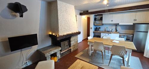 un salon avec une table et une cheminée dans l'établissement Pied des pistes app 5 personnes, à La Clusaz